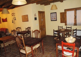 Zona de comedor en el interior del salón de la casa rural con varias mesas