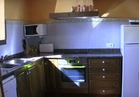 Cocina con armarios de madera y detalles anaranjados