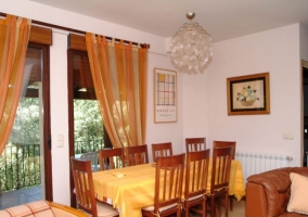 Sala de estar con mesa de comedor y ventanales