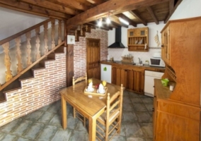 Cocina con mesa de madera y alacena