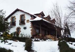 Fachada de la casa en invierno rodeada de nieve