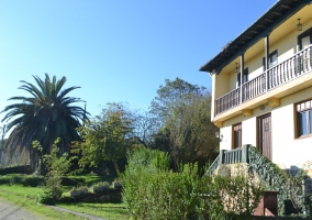 Vista de la fachada de la casa y jardines