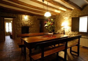 Salón de piedra con vigas vistas y chimenea