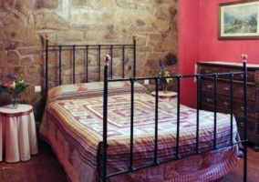 Dormitorio doble con techos abuhardillados y colchas rojas