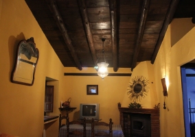 Salón con mesa de comedor con sillas, chimenea y televisor