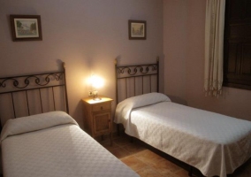 Dormitorio doble con colchas blancas en casa rural