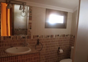 Baño con azulejos ocres en casa rural