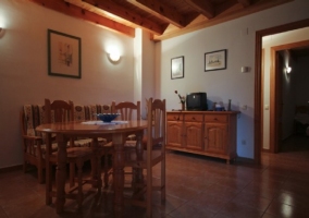 Salón comedor con televisor, mesa y cocina