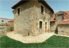 Fachada lateral de piedra de la casa rural 