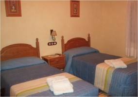 Dormitorio de matrimonio con mobiliario de madera y pared de piedra