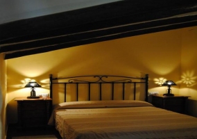 Dormitorio con techo abuhardillado