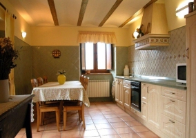 Cocina blanca con mesa para comer seis personas