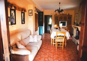 Salón con chimenea de piedra y puertas y contraventanas de madera