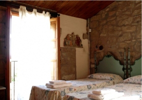 Dormitorio con camas individuales y cabeceros antiguos en la casa rural