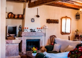 Salón con chimenea de piedra y mobiliario