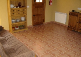 Zona con baldosas y muebles de exterior junto a la tierra del patio