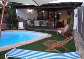 Vistas de la piscina y la terraza cubierta de la casa rural