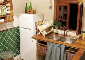 Cocina con azulejos en color verde y nevera
