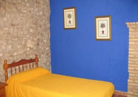 Dormitorio con pared de piedra