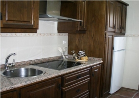 Cocina moderna con vitroceramica y muebles de madera en la casa rural