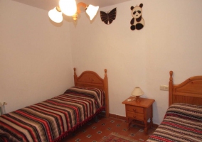 Dos camas individuales con colchas a rayas