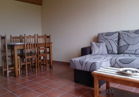 Sala de estar con el sofá cama y techo de madera