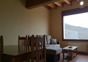 Sala de estar con sofá cama en forma de L y mesa del comedor