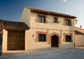 Fachada del alojamiento con puerta grande de madera