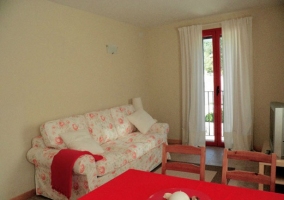 Sala de estar con mesa de comedor y mantel rojo