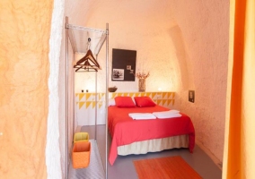 Cama de matrimonio y perchero en la habitación
