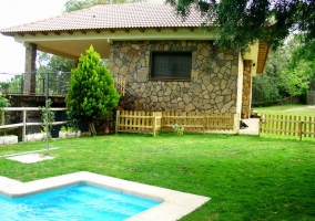 Jardín con barbacoa y piscina de fondo