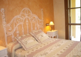 Habitación de matrimonio naranja con cabecero pintado