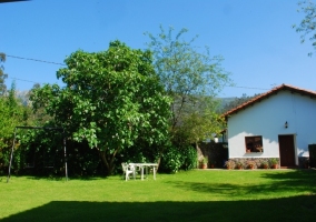 Vista de la casa y patio con muebles