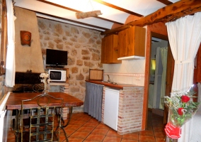 Cocina, mesa de comedor, televisión y chimenea