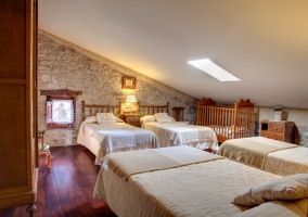 Dormitorio de cuatro camas individuales con cuna en la casa rural