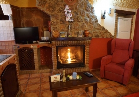 Sala con chimenea y cocina abierta