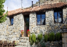 Vista de la entrada a la casa desde el jardín, con mesa de comedor