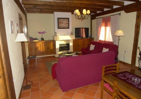 Sala de estar con chimenea y televisor grande al lado