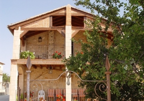 Vista de la fachada de la casa con dos plantas y terraza