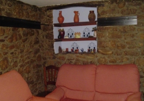 Sala de estar con sofás y pared de piedra