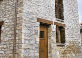 Acceso a la casa en piedra y su puerta en madera