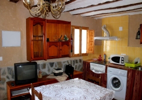 Sala principal con televisor y cocina