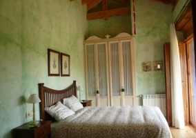 Cama de habitación de matrimonio con salida al balcón de casa rural