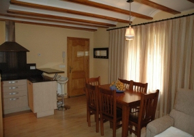 Sala de estar con televisor y cocina abierta