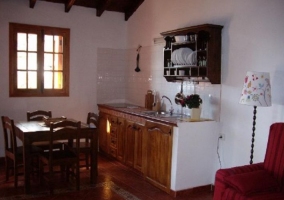 Cocina comedor con mesa de madera y sillones