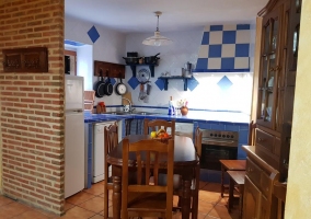 Cocina de la casa en azul y blanco con mesa de madera