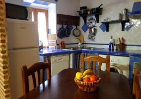 Cocina con una mesa de madera y las sillas