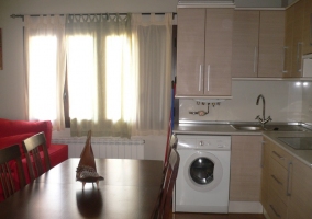 Mesa grande y cocina abierta con lavadora