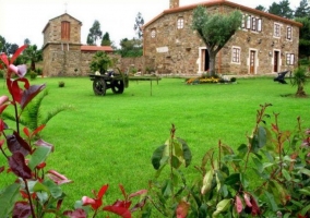 Acceso principal con la casa de fachada en 2 plantas