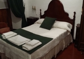 Dormitorio de matrimonio con toallas sobre la colcha